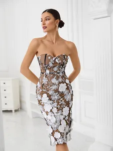 Detailed view of white floral embroidery on a brown strapless mesh party dress