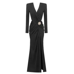 Elegant black long sleeve V-neck maxi evening dress with draped waist and crystal brooch