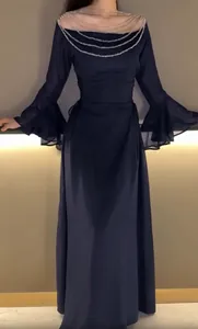 Dettaglio abito da sera blu navy con scollo a catenella di perline e maniche a campana.