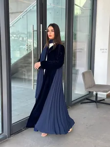 Elegant navy blue velvet abaya with pleated side panels shown in a lifestyle setting.