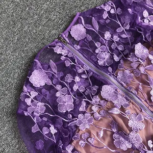 Close-up detail of elegant purple floral lace embroidery on long sleeve banquet dress