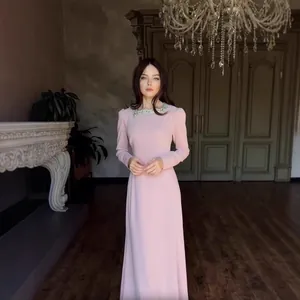 Elegantes langes rosa Kleid mit Strasskragen an einem Model in einem klassischen Interieur