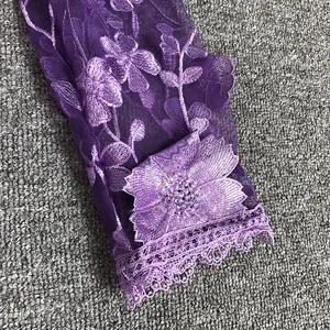 Macro detail of purple floral lace sleeve with intricate embroidery on elegant dress