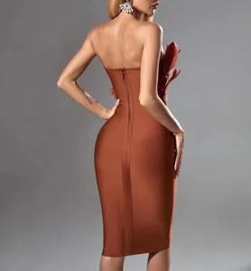 Detailed back view of an elegant burnt orange strapless bandage midi dress with feathers