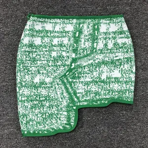 Trendy green and white jacquard mini skirt featuring a unique asymmetric hemline design.