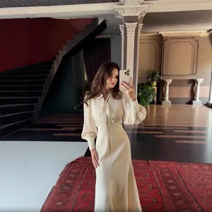 Elegantes französisches cremefarbenes Maxikleid mit Taillierung, Schluppe und Plissee-Ärmeln.