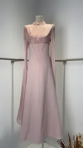Détail d'une robe de couture rose avec des manches scintillantes et une taille haute.