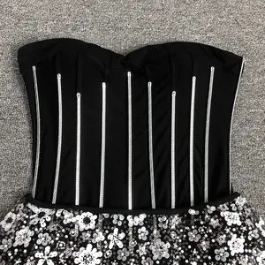 Macro view of the silver sequined stripes and white floral beaded detail on a black dress