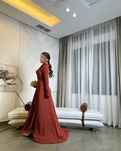 Elegantes langärmeliges Abendkleid mit Faltenrock in einer modernen Inneneinrichtung