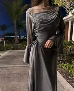 Dettaglio di un abito da sera grigio scintillante con elegante scollatura a catena decorata.