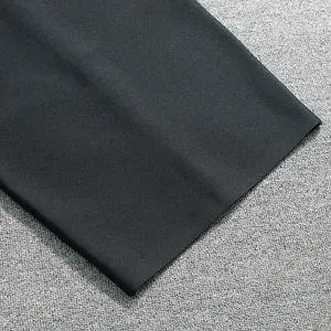 Detailed close-up of high-quality black bandage dress fabric texture and fine edge finish
