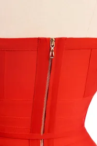 Gros plan du détail de la fermeture éclair arrière sur une robe bandage rouge vif