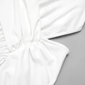Detailed macro view of the elegant white crossover dress showing pleated fabric texture