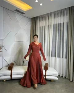 Detailansicht eines rostigen Abendkleids mit plissiertem Rock und eleganten langen Ärmeln