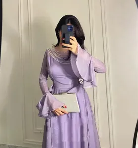 Dettaglio di un elegante vestito lungo viola con maniche a campana e scollo decorato