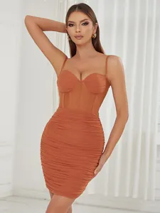 Dettaglio di un sexy vestito aderente arricciato color terracotta con corpetto e spalline.