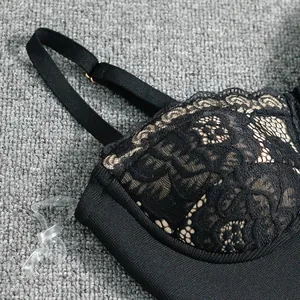 Detail shot showing intricate black floral lace and adjustable strap of a bandage dress