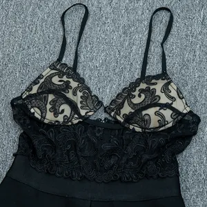 Close-up of black lace embroidery and slim straps on an elegant bandage jumpsuit