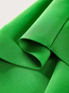 Close-up detail of high-quality green ribbed fabric texture for bandage dresses.