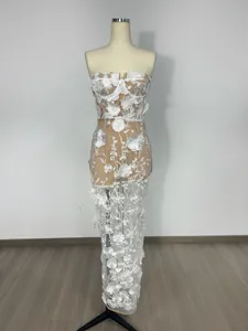 Close-up detail of a white 3D floral embroidery strapless long evening gown on mannequin.