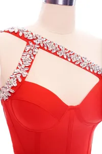 Dettaglio di un abito bandage rosso con spallina decorata da strass scintillanti