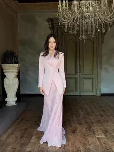 Elegant pink textured suit set with blazer and long skirt for women in formal setting