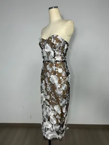 Side profile view of elegant strapless mesh evening dress with white floral embroidery detail