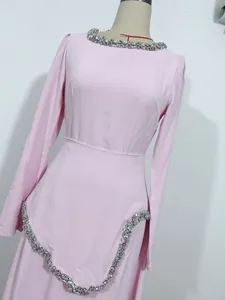 Elegantes hellrosa Langarmkleid mit silbernen Strassdetails an Ausschnitt und Taille.