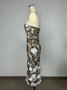 Detailed side view of strapless mesh evening dress with white floral embroidery on mannequin