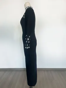 Vista laterale di abito nero a maniche lunghe con decorazioni in strass sui polsini