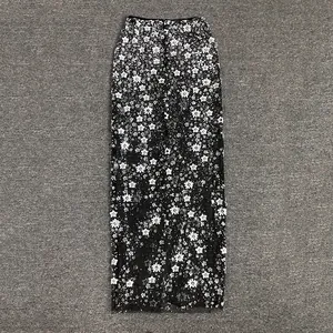 Detailed texture of black mesh skirt with intricate white sequined floral beaded patterns