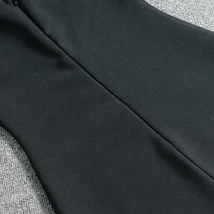 Close-up detail of high-quality black bandage dress fabric with hidden zipper closure