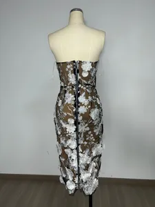Detailed back view of mesh embroidered dress with white floral pattern and zipper.