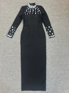 Dettaglio di un elegante abito nero con lussuose decorazioni in strass e inserto in rete