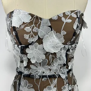 Detailed view of white floral embroidery on a brown mesh strapless party dress
