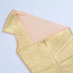 Detailed shot of a gold bronzed bandage dress with one-shoulder design and zipper.