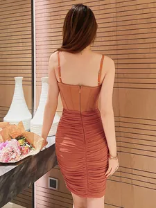 Dettaglio posteriore di un abito a corsetto fasciante arancione ruggine arricciato