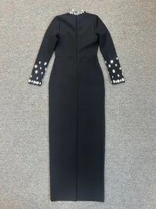 Elegante abito lungo nero aderente a maniche lunghe con dettagli su colletto e polsini in strass