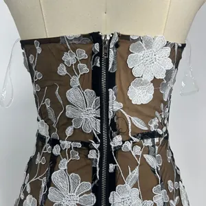 Detail of the back zipper and exquisite white floral embroidery on black mesh tube dress.