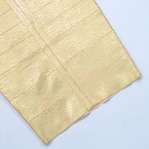 Macro detail shot showing the shimmering gold foil texture of metallic bandage dress fabric