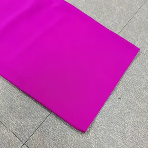 Macro view showing the vibrant fuchsia ribbed texture of a high-quality bandage dress fabric