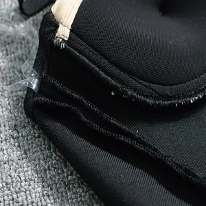 Detailed macro view of black bandage dress showing intricate stitching and clear strap.