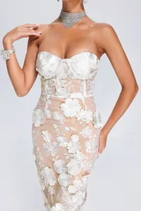 Detailed view of elegant white lace dress with 3D floral embroidery and strapless neckline