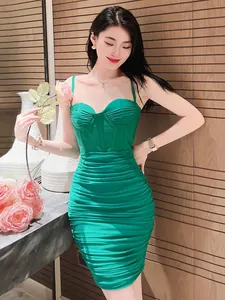 Dettaglio dell'elegante abito verde attillato con arricciature e spalline sottili
