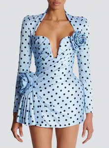 Detailed view of elegant light blue polka dot dress with 3D floral accents and V-neckline