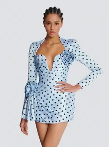 Detailed shot of an elegant light blue polka dot mini dress with 3D floral accents