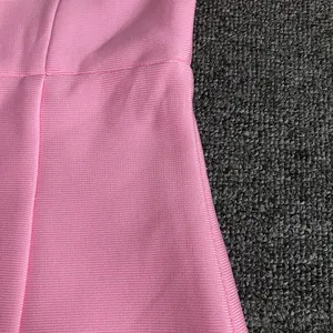 Primo piano del tessuto bandage rosa testurizzato con trama a coste e dettaglio cuciture.