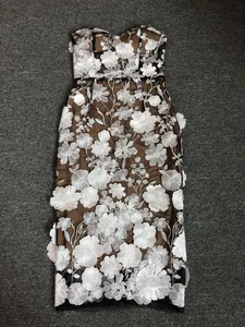 Detailed view of the intricate white floral embroidery on a strapless mesh evening party dress