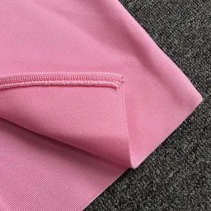 Dettaglio ravvicinato del tessuto a coste rosa e cuciture dell'elegante abito aderente
