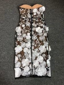 Detailed view of back zipper on strapless mesh dress with white floral embroidery.